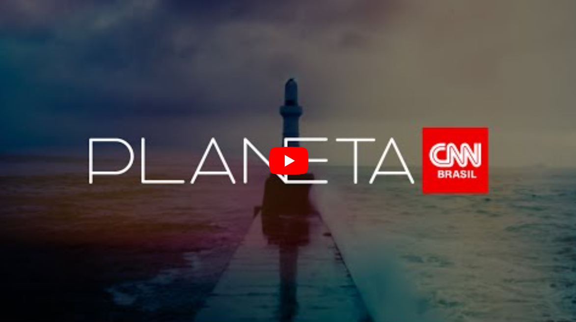 Miniatura de vídeo, mostrando o programa PLANETA CNN BRASIL. A imagem de fundo mostra uma paisagem marítima com um céu nublado. Ao centro, um longo píer se estende em direção a um farol.